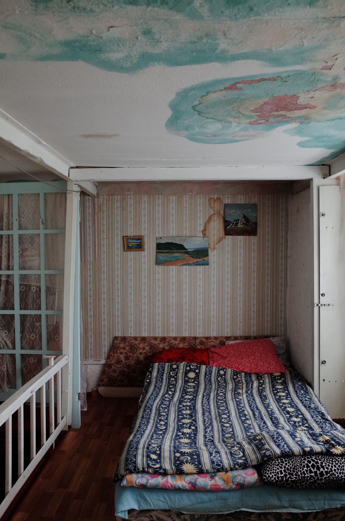A water-damaged ceiling corner showing a stain and peeling paint